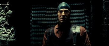 Movie still from “Hostel: Part II” (2007), directed by Eli Roth – A man wearing a hat and a leather jacket; Close Up shot, Low angle