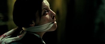 Movie still from “Hostel: Part II” (2007), directed by Eli Roth – A person with a white cloth around their mouth; Close Up shot, Low angle