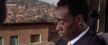 Movie still from “Hotel Rwanda” (2004), directed by Terry George – A person wearing a suit and tie; Close Up shot, Over the shoulder angle