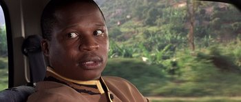 Movie still from “Hotel Rwanda” (2004), directed by Terry George – A person's face in front of a forest; Close Up shot, Over the shoulder angle