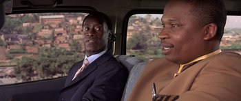 Movie still from “Hotel Rwanda” (2004), directed by Terry George – Two men in suits sitting in the back of a car; Close Up shot, Over the shoulder angle