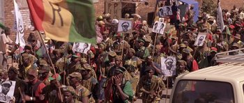 Movie still from “Hotel Rwanda” (2004), directed by Terry George – A group of people holding up signs in a parade; Medium shot, High angle