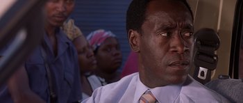 Movie still from “Hotel Rwanda” (2004), directed by Terry George – A person wearing a shirt and a tie; Close Up shot, Over the shoulder angle