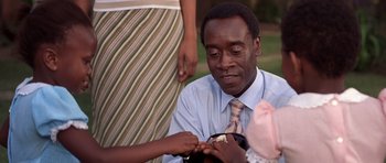 Movie still from “Hotel Rwanda” (2004), directed by Terry George – A man in a blue dress shirt and a woman in a pink dress; Close Up shot, Over the shoulder angle