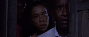 Movie still from “Hotel Rwanda” (2004), directed by Terry George – A man and a woman standing next to each other in the dark; Close Up shot, Low angle