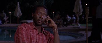Movie still from “Hotel Rwanda” (2004), directed by Terry George – A man in a red shirt is talking on a cell phone; Close Up shot, Low angle