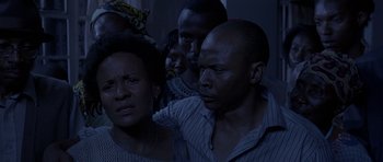 Movie still from “Hotel Rwanda” (2004), directed by Terry George – A group of people that are standing in a room together; Close Up shot, High angle