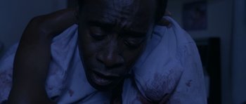 Movie still from “Hotel Rwanda” (2004), directed by Terry George – A person with blood on his face; Close Up shot, High angle