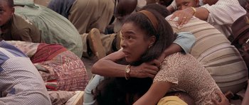 Movie still from “Hotel Rwanda” (2004), directed by Terry George – A woman sitting on the ground hugging another woman; Close Up shot, High angle