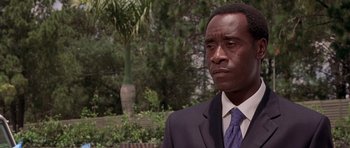 Movie still from “Hotel Rwanda” (2004), directed by Terry George – A man in a suit and tie standing in front of a tree; Close Up shot, Low angle