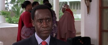 Movie still from “Hotel Rwanda” (2004), directed by Terry George – A person wearing a suit and tie; Close Up shot, Over the shoulder angle