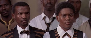 Movie still from “Hotel Rwanda” (2004), directed by Terry George – A group of men standing next to each other wearing ties; Close Up shot, Low angle