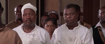Movie still from “Hotel Rwanda” (2004), directed by Terry George – A group of people standing in front of a wall; Close Up shot, Low angle
