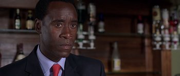Movie still from “Hotel Rwanda” (2004), directed by Terry George – A person wearing a suit and tie; Close Up shot, Over the shoulder angle