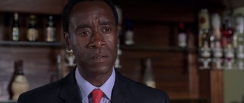 Movie still from “Hotel Rwanda” (2004), directed by Terry George – A person wearing a suit and tie; Close Up shot, Over the shoulder angle