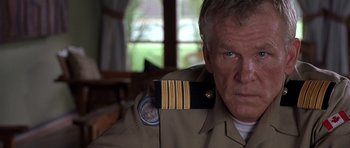 Movie still from “Hotel Rwanda” (2004), directed by Terry George – A person wearing a uniform; Close Up shot, Over the shoulder angle