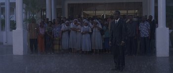 Movie still from “Hotel Rwanda” (2004), directed by Terry George – A group of people standing in front of a building; Wide shot, Low angle