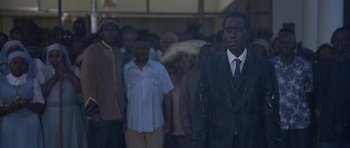 Movie still from “Hotel Rwanda” (2004), directed by Terry George – A group of people standing in front of a building; Medium shot, Low angle