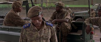 Movie still from “Hotel Rwanda” (2004), directed by Terry George – A group of men sitting on top of each other; Close Up shot, Low angle