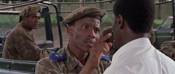 Movie still from “Hotel Rwanda” (2004), directed by Terry George – A man in a military uniform talking to another man; Close Up shot, Over the shoulder angle