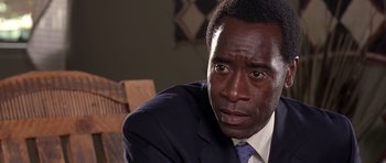 Movie still from “Hotel Rwanda” (2004), directed by Terry George – A person wearing a suit and tie; Close Up shot, Over the shoulder angle