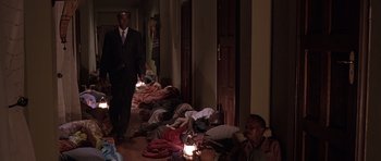 Movie still from “Hotel Rwanda” (2004), directed by Terry George – A group of people sleeping on the floor in a room; Wide shot, High angle