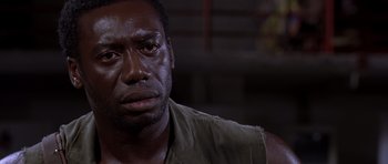 Movie still from “Hotel Rwanda” (2004), directed by Terry George – A person wearing a shirt; Close Up shot, Over the shoulder angle