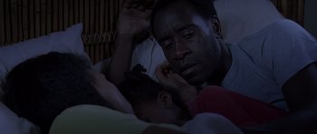 Movie still from “Hotel Rwanda” (2004), directed by Terry George – A man and a child laying in a bed together; Close Up shot, High angle