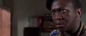 Movie still from “Hotel Rwanda” (2004), directed by Terry George – A person wearing a uniform; Close Up shot, Over the shoulder angle