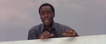 Movie still from “Hotel Rwanda” (2004), directed by Terry George – A man with a ring on his finger pointing at something; Close Up shot, Low angle