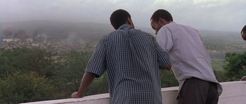 Movie still from “Hotel Rwanda” (2004), directed by Terry George – Two men looking out over a valley from a balcony; Medium shot, Low angle