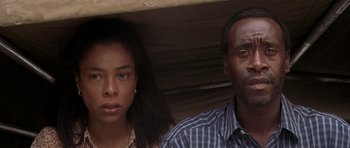 Movie still from “Hotel Rwanda” (2004), directed by Terry George – A man and a woman standing next to each other; Close Up shot, Low angle