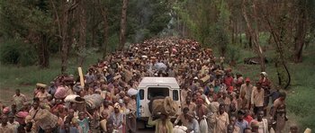 Movie still from “Hotel Rwanda” (2004), directed by Terry George – A large group of people walking down a road; Extreme Wide shot, High angle