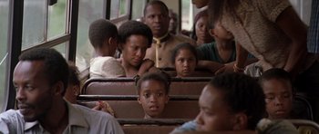 Movie still from “Hotel Rwanda” (2004), directed by Terry George – A group of people sitting on a bus; Close Up shot, Over the shoulder angle