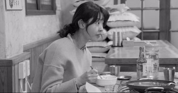 A woman sitting at a table with a bowl of food