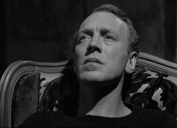 A black and white photo of a man sitting in a chair