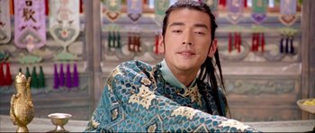 Movie still from “House of Flying Daggers” (2004), directed by Yimou Zhang – A man with long black hair wearing a blue and yellow shirt; Close Up shot, Over the shoulder angle