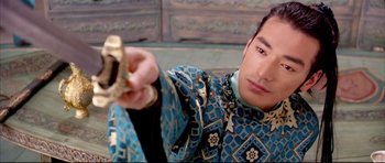Movie still from “House of Flying Daggers” (2004), directed by Yimou Zhang – A man in a blue and gold jacket holding a camera; Close Up shot, Over the shoulder angle