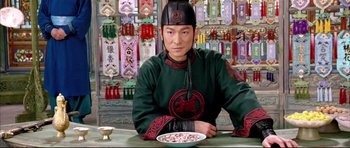 Movie still from “House of Flying Daggers” (2004), directed by Yimou Zhang – A man sitting at a table in front of a plate of food; Medium shot, Low angle