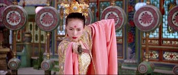 Movie still from “House of Flying Daggers” (2004), directed by Yimou Zhang – A woman dressed in traditional chinese clothing holding a sword; Medium shot, Over the shoulder angle
