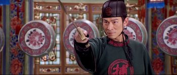 Movie still from “House of Flying Daggers” (2004), directed by Yimou Zhang – A man holding a sword in front of stained glass windows; Close Up shot, Low angle