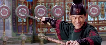 Movie still from “House of Flying Daggers” (2004), directed by Yimou Zhang – A man holding a sword in front of a wall; Medium shot, Over the shoulder angle