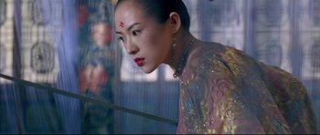 Movie still from “House of Flying Daggers” (2004), directed by Yimou Zhang – A woman in a pink and gold dress with red lipstick; Medium shot, Low angle