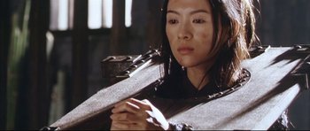 Movie still from “House of Flying Daggers” (2004), directed by Yimou Zhang – A woman holding a gun in a room; Medium shot, High angle