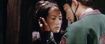 Movie still from “House of Flying Daggers” (2004), directed by Yimou Zhang – A young asian woman touching the ear of a young asian man; Close Up shot, Over the shoulder angle