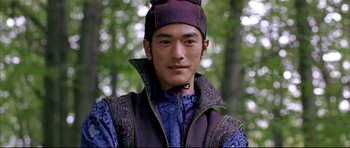 Movie still from “House of Flying Daggers” (2004), directed by Yimou Zhang – A man in a purple outfit standing in the woods; Close Up shot, Over the shoulder angle