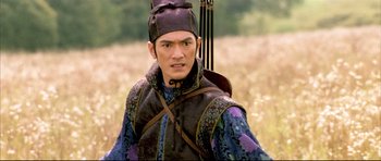 Movie still from “House of Flying Daggers” (2004), directed by Yimou Zhang – A man with a bow and arrow in a field; Close Up shot, Over the shoulder angle