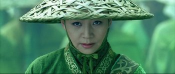 Movie still from “House of Flying Daggers” (2004), directed by Yimou Zhang – A woman wearing a green outfit and a straw hat; Close Up shot, High angle