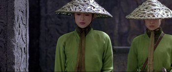 Movie still from “House of Flying Daggers” (2004), directed by Yimou Zhang – A woman wearing a green shirt and a hat; Medium shot, High angle