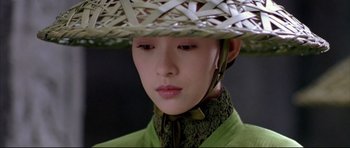 Movie still from “House of Flying Daggers” (2004), directed by Yimou Zhang – A woman wearing a hat and a green shirt; Close Up shot, High angle